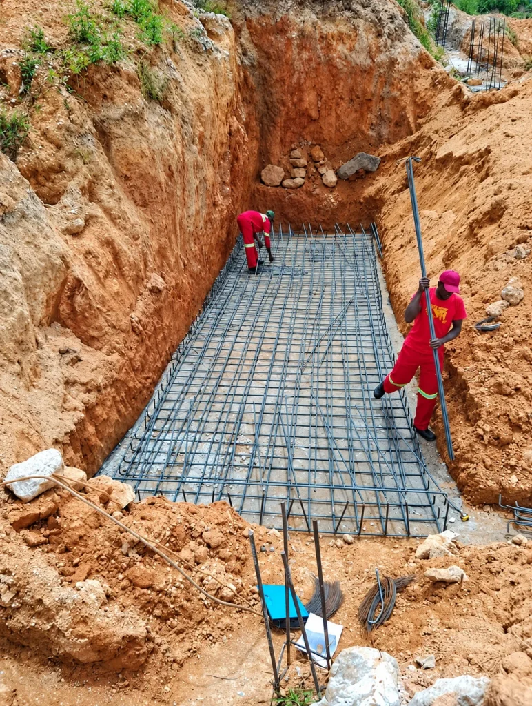 Steel Total team fixing reinforcement inside a foundation excavation